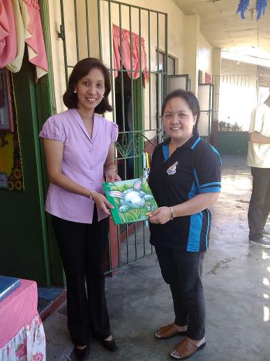 Ms. Mactal, handling books to the OIC of the Library